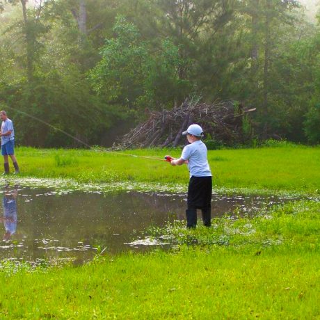 Father and son fishing in the pond at Green Woods Stables RV Park